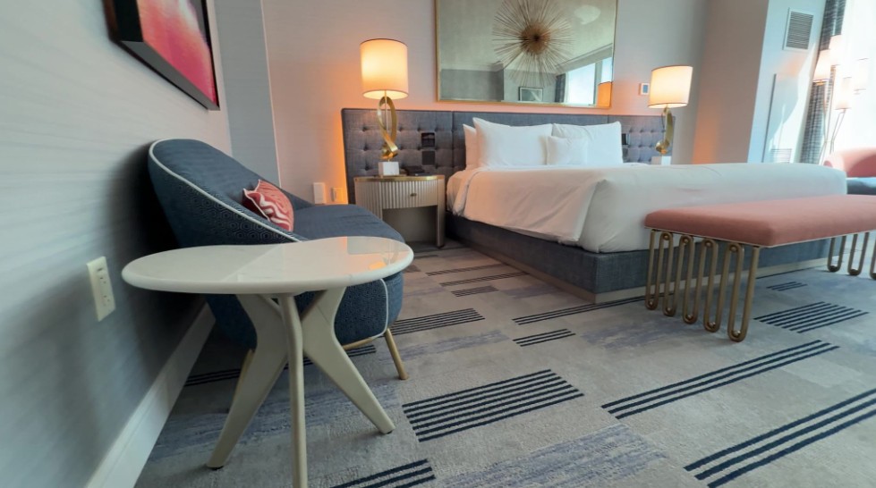 A chair and small table against the wall, facing the king bed.