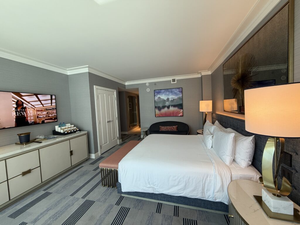 A final angle of the bed pointed at the TV, the entry to the room in the background.