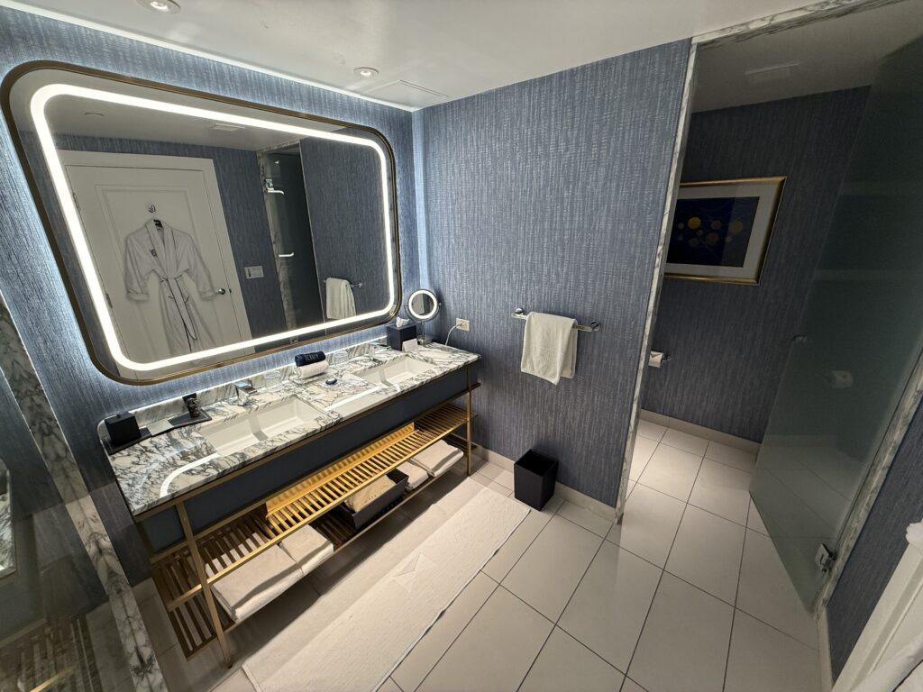 A dual vanity sink topped by an illuminated mirror. 