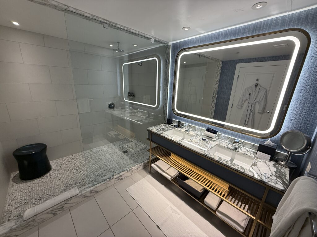 The dual vanity sink from another angle that clearly shows the massive glass-enclosed shower. 