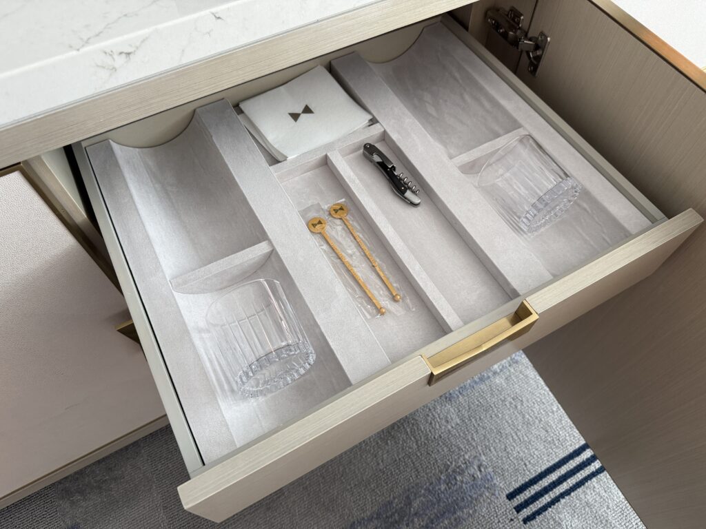 A drawer with additional cups and stir sticks. 