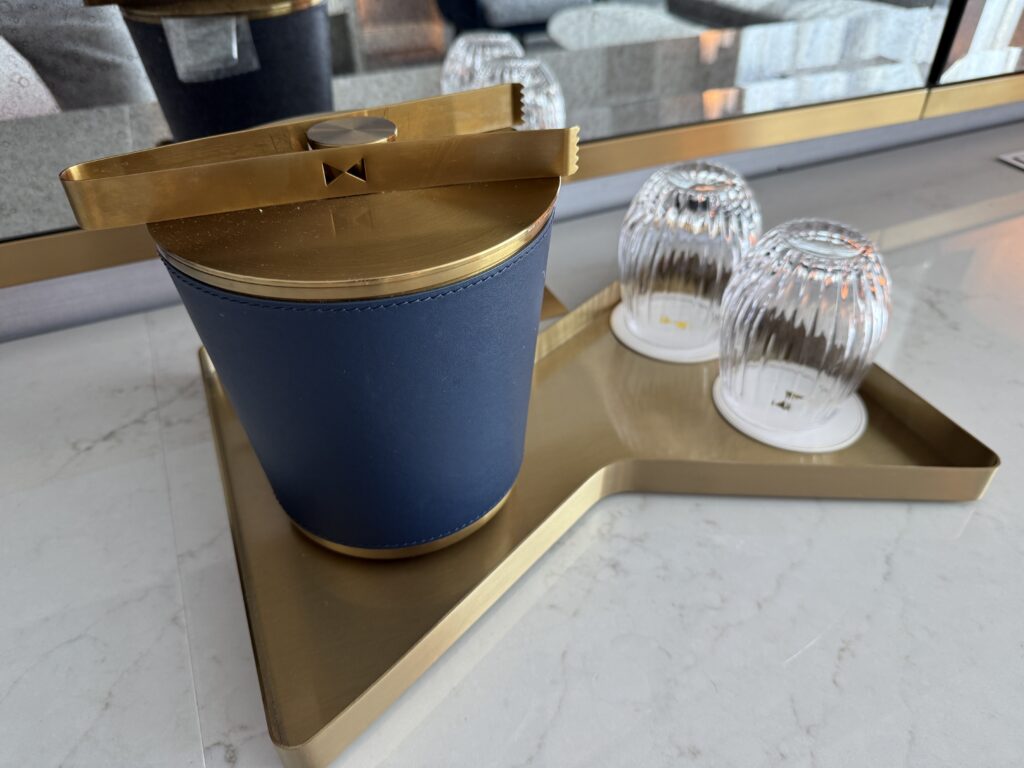 An ice bucket next to two glasses. 