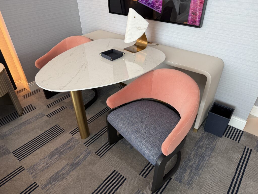 Two chairs around a table, bedside. 