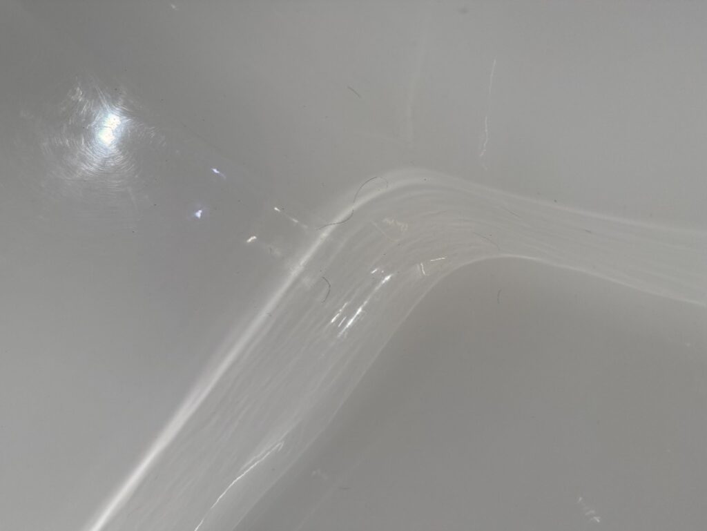 Hairs in the corner of a bathtub.