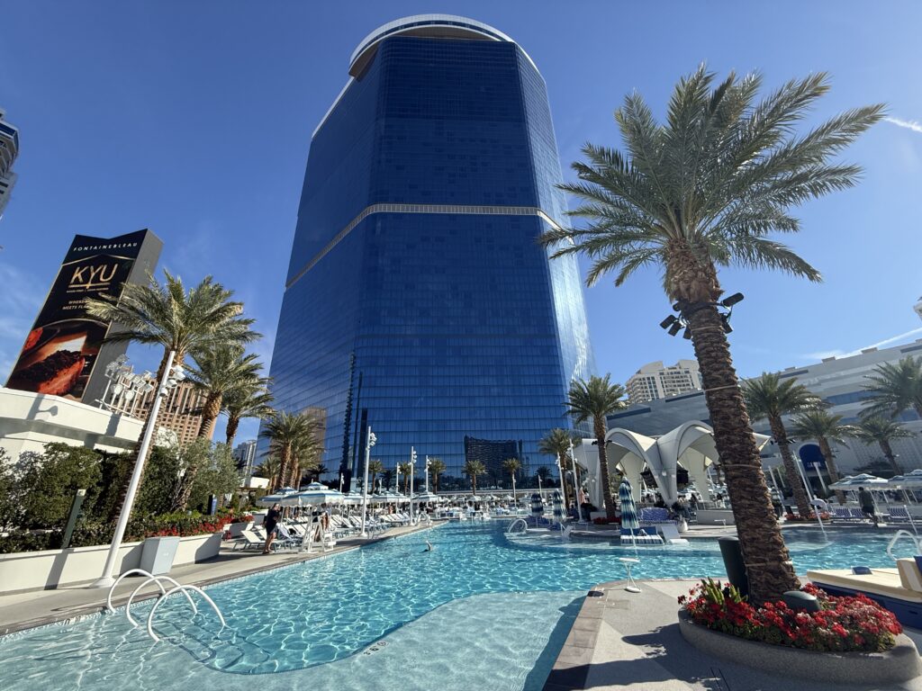 The pool and a palm tree in the foreground, and Fontainebleau's hotel tower in the background. 
