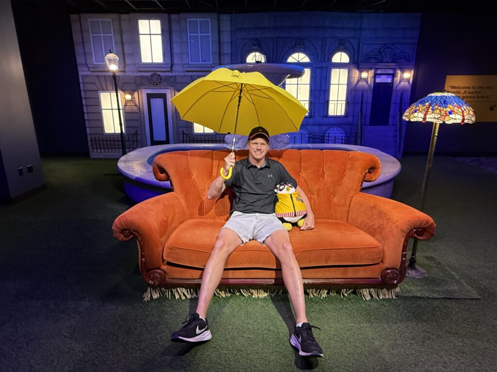 Me, sitting on the iconic couch in front of a fountain holding a yellow umbrella. 
