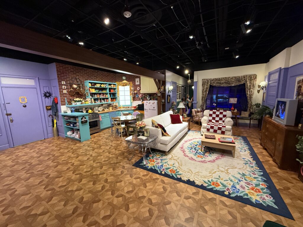 A set recreation of Monica and Rachel's apartment, with the kitchen and entry door to the left and living area to the right. 