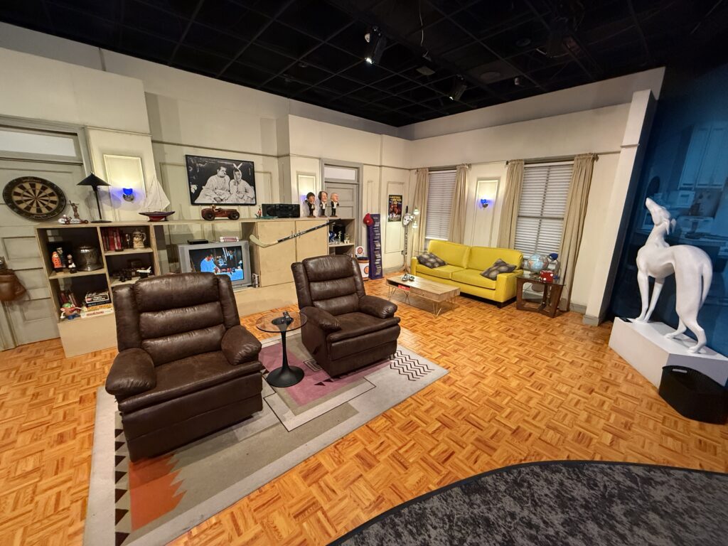 Joey & Chandler's apartment set recreation with two leather seats on a rug facing a TV. 