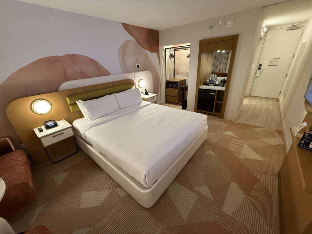 Another angle of the room that shows the open closet without a door, minibar, and entryway. 
