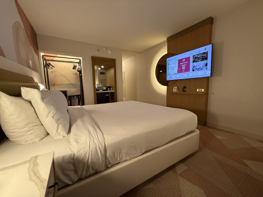 A view from the seating of the TV. The king bed is also in the foreground. 