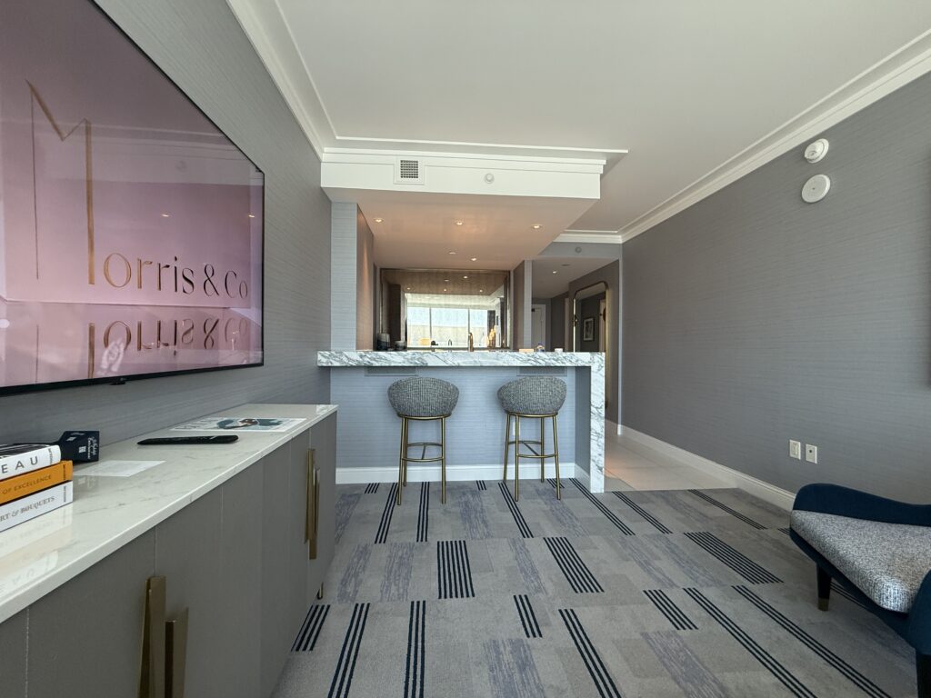 A view of the bar form the living area, with 2 stools pushed up against the bar. 