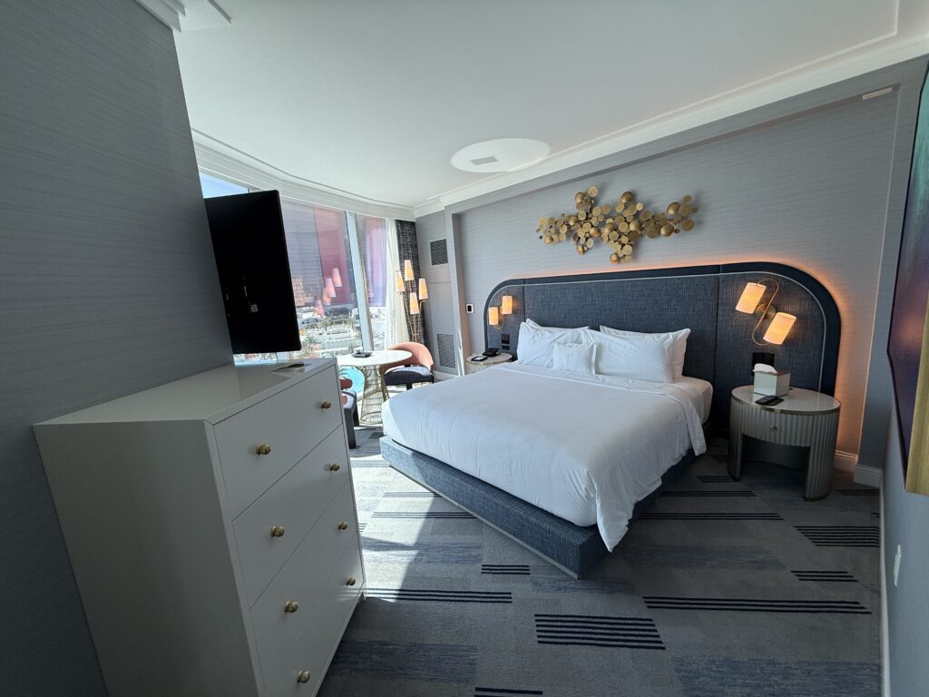 Another angle of the room which shows a dresser against a wall wit hteh king bed in the background. 