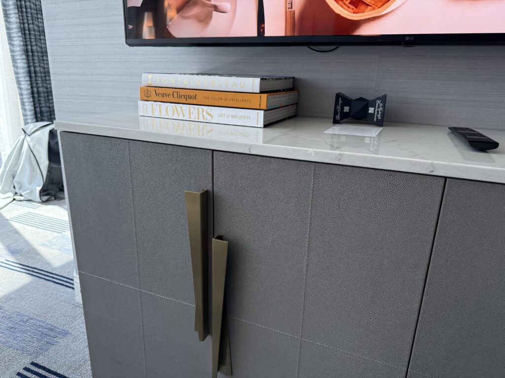A stack of books underneath the TV in the living area. 