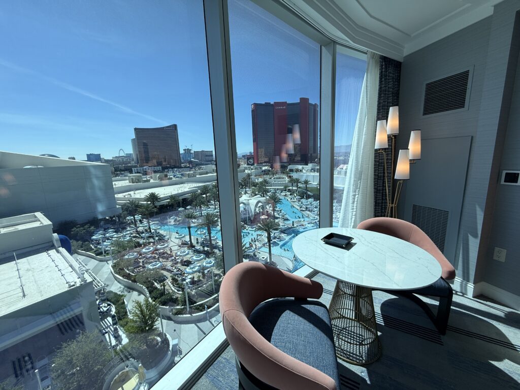 A small table, with two chairs in front of the window in the bedroom. 