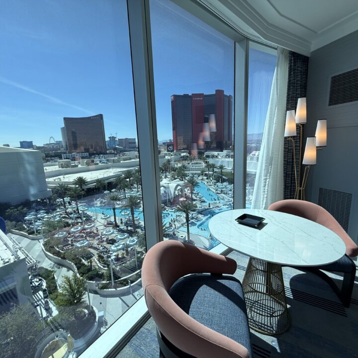 A small table, with two chairs in front of the window in the bedroom.