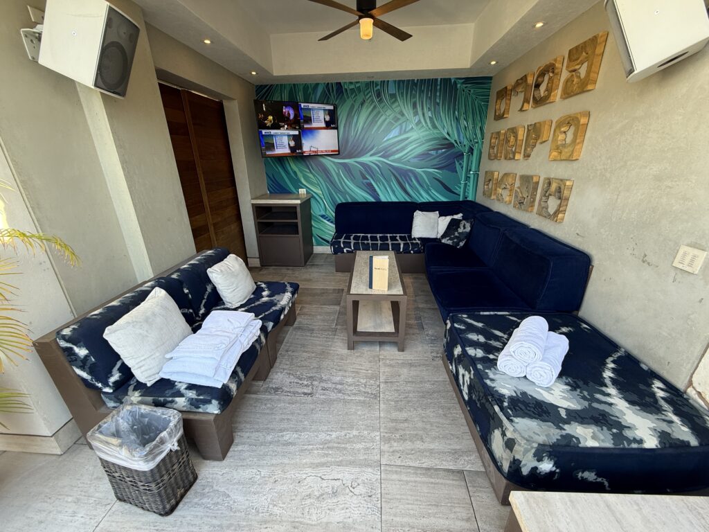 A cabana with a TV, couch, and chair. 