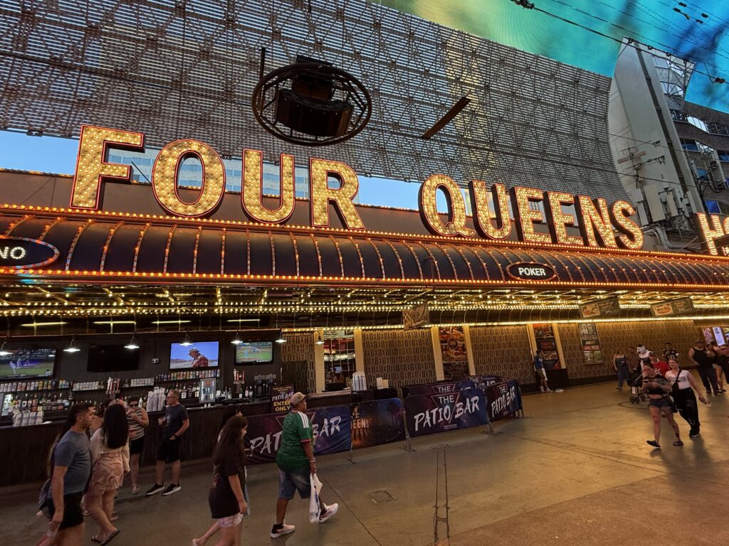 Exterior signage that says "Four Queens" in illuminated lettering.