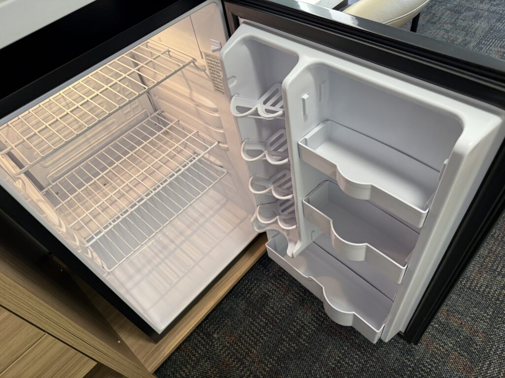 An open, empty mini fridge.