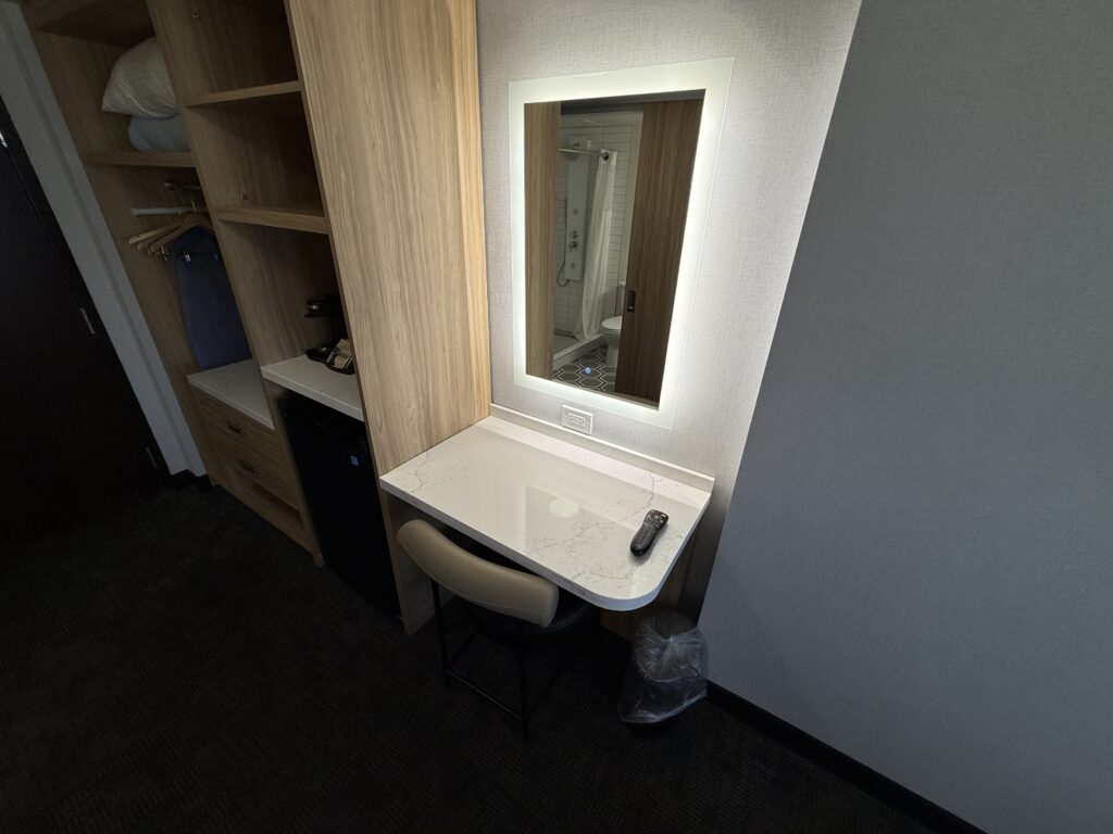 A desk with a backlit mirror atop it.