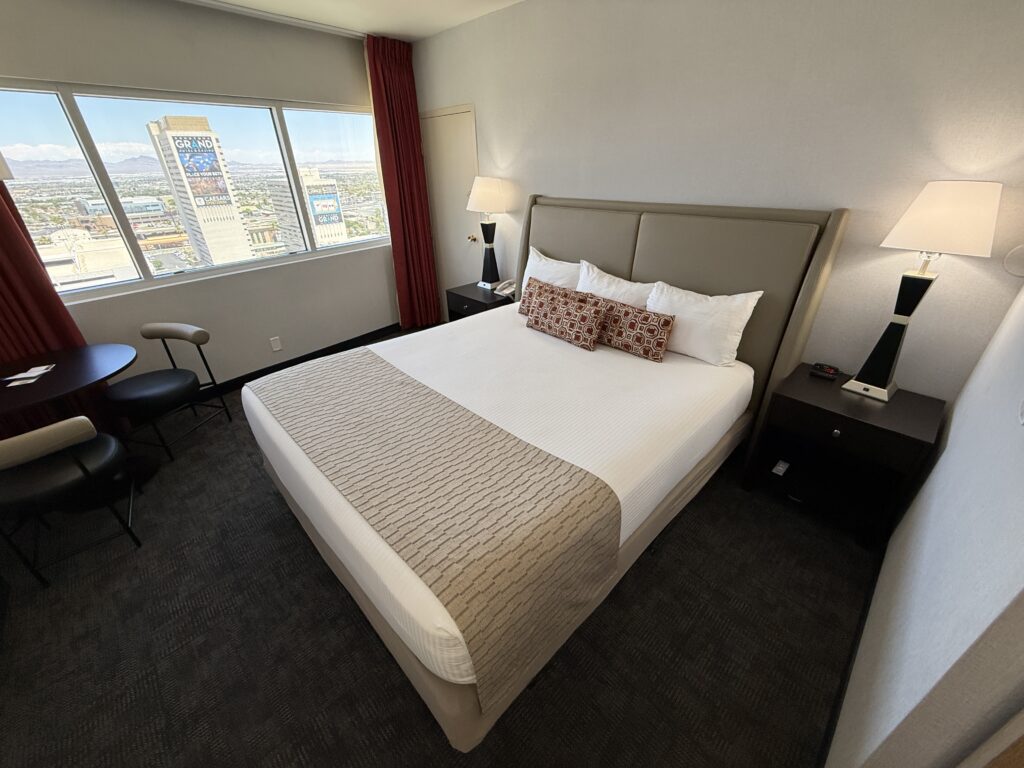 A wide angle view of the room that shows the king bed with the window in the background.