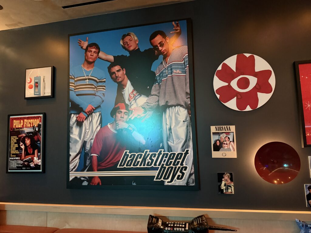 Framed Backstreet Boys poster as part of a retro wall gallery with other pop-culture posters nearby