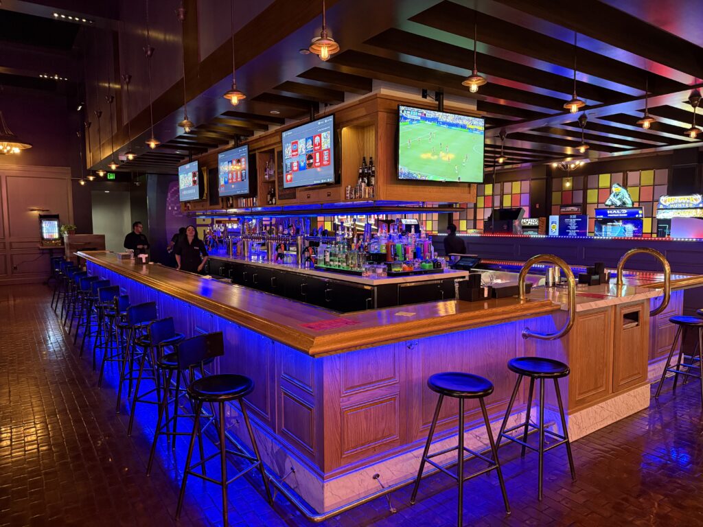 Bar at Bonus Round, with stools lined up and TVs hanging above. 
