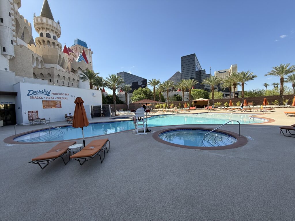 A large pool with Luxor visible in the background. A circular hot tub is in the foreground. 