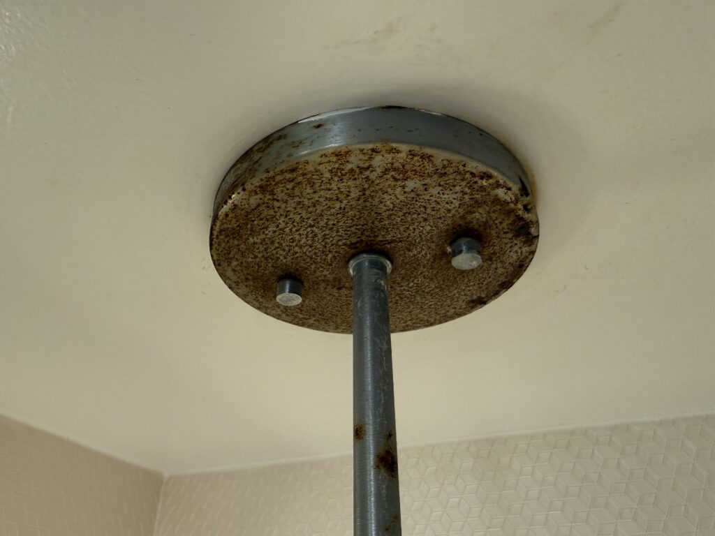Close-up of a rusted circular light fixture mount.