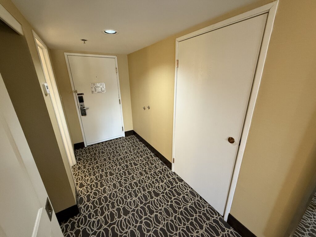 Entryway to the room, which is bland, despite having new carpeting.