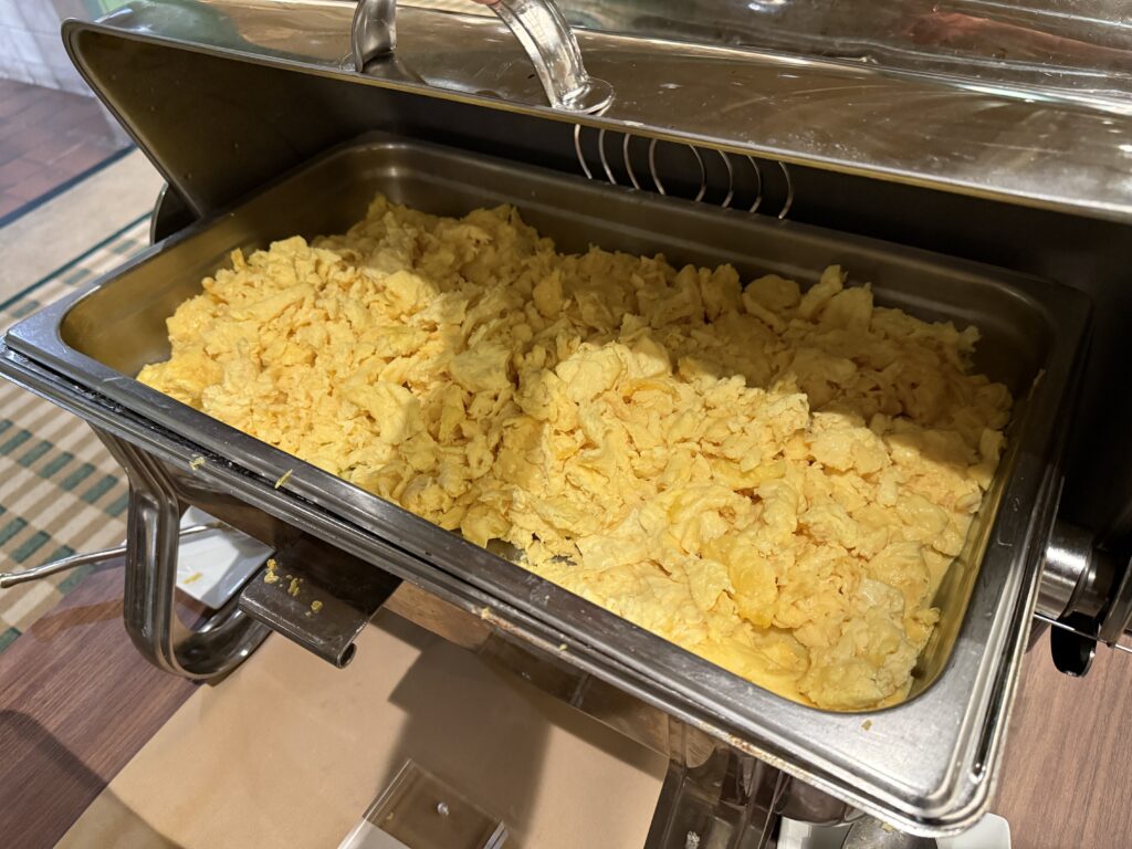 A warming tray stocked with standard scrambled eggs. 