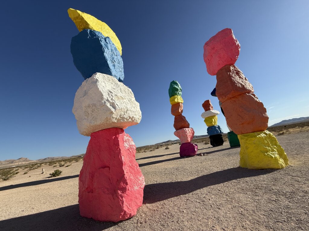 4 colorful rock formations with a blue sky in the background.