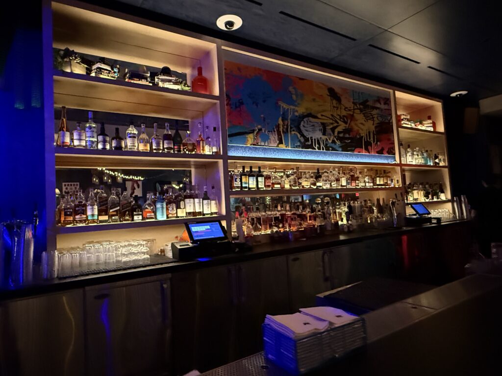 Illuminated bottles on the back wall of the Bar at Close Company. 