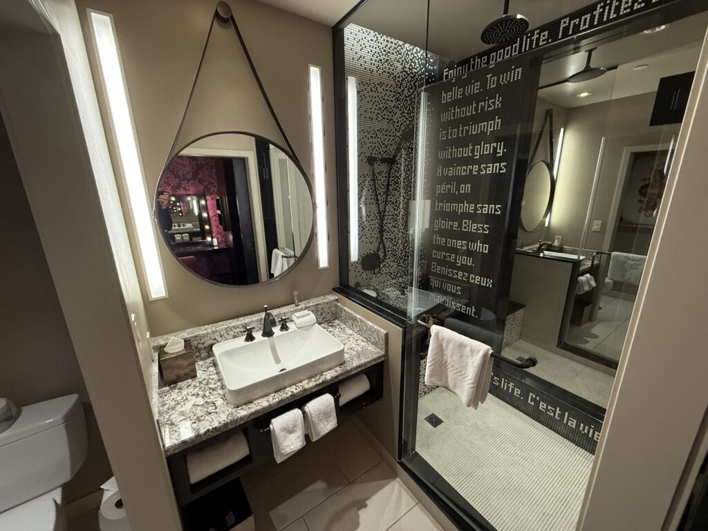 The Cromwell's Bathroom, with a single sink vanity and a shower in the background.
