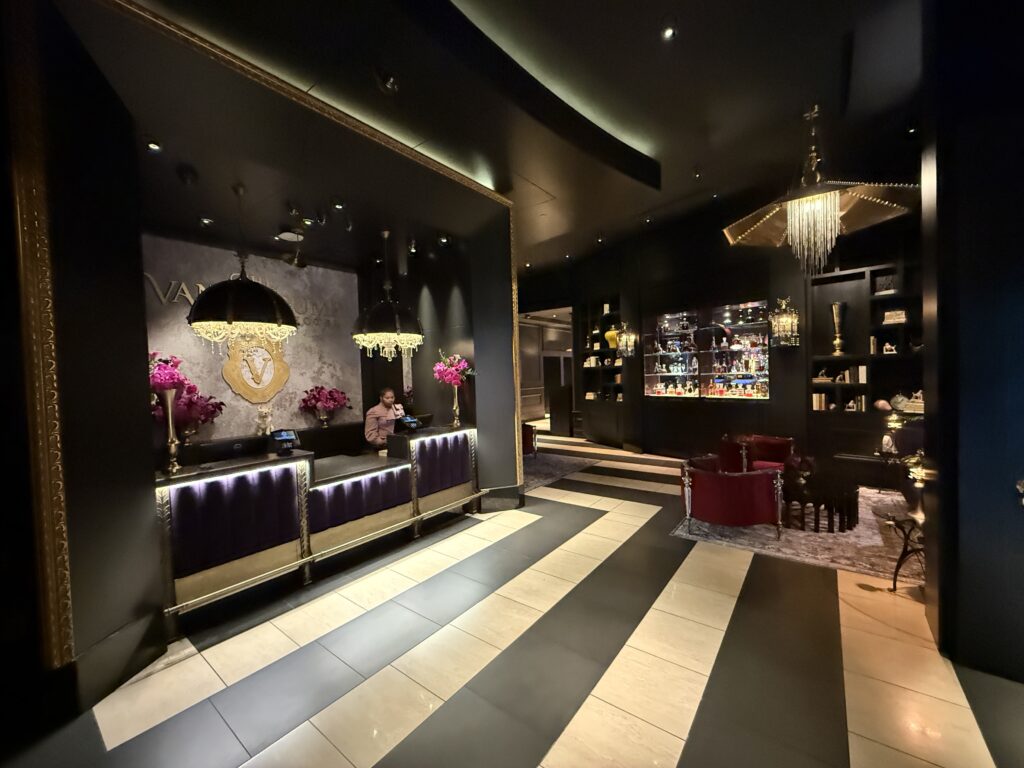A wide angle view of the hotel lobby, with the front desk visible on the left and decor on the right. 