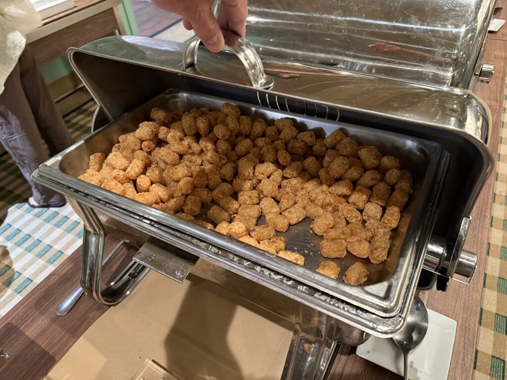 A warming tray piled high with tater tots. 