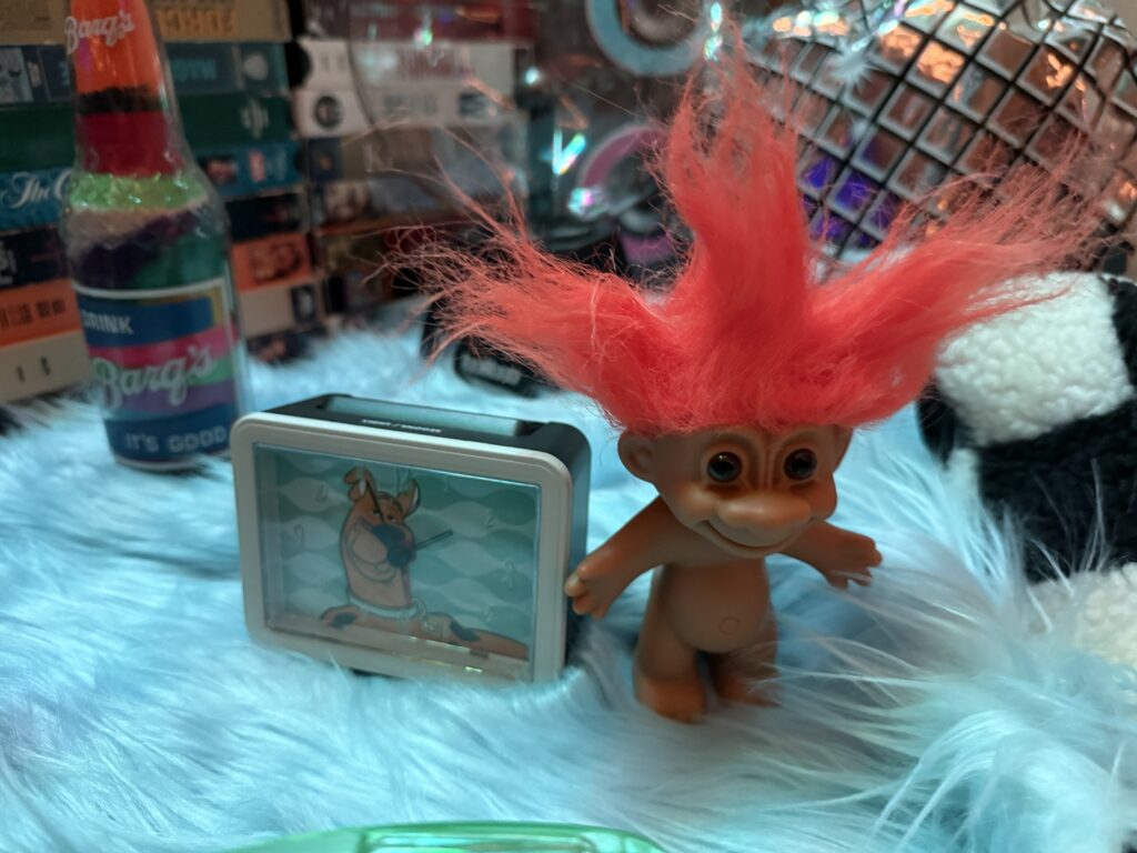 A close up of a Troll doll with crazy hair. 