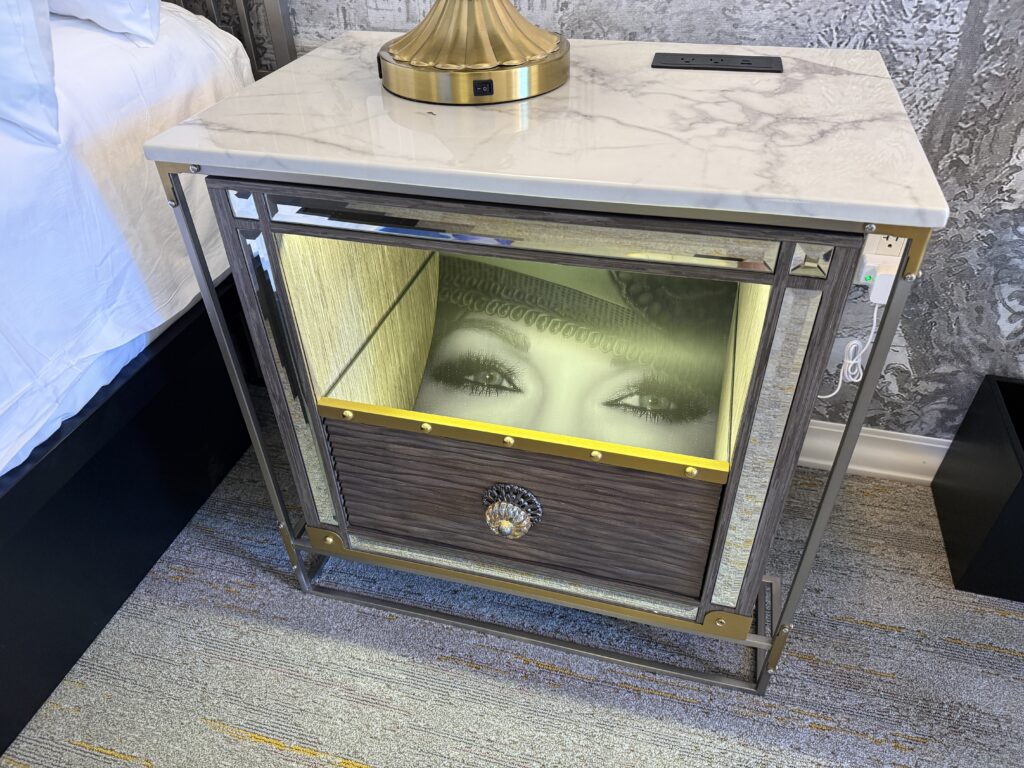 An end table with an illuminated set of eyes peering out. 