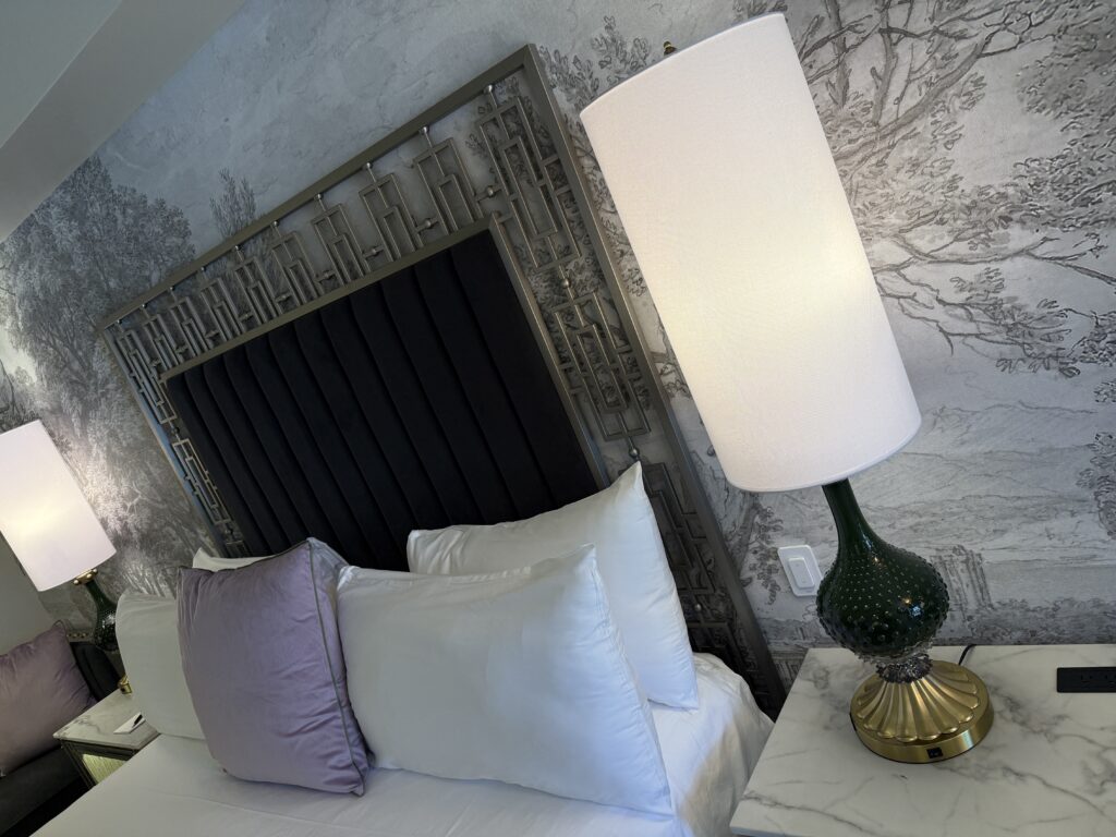 A lamp on a side table next to the bed, which is also in the picture. 