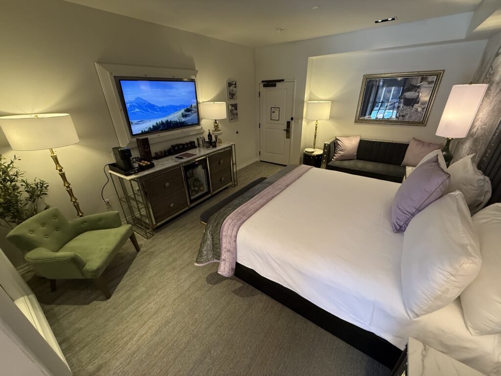 Another angle of the room, which shows the bed pointed at the TV, and a couch in the background. 