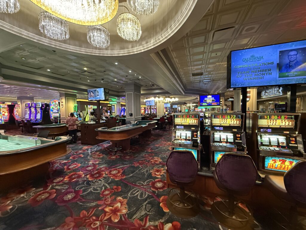 Table games to the left and slot machines lined up on the right on the casino floor. 
