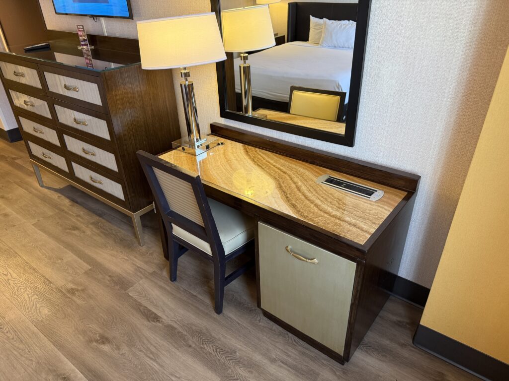 A closeup of the workdesk with a chair pushed in.