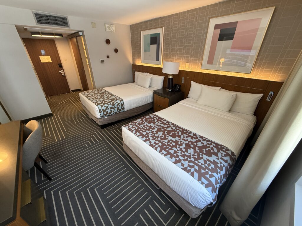 Another angle of the room that shows the two beds with two pieces of art hanging above. 