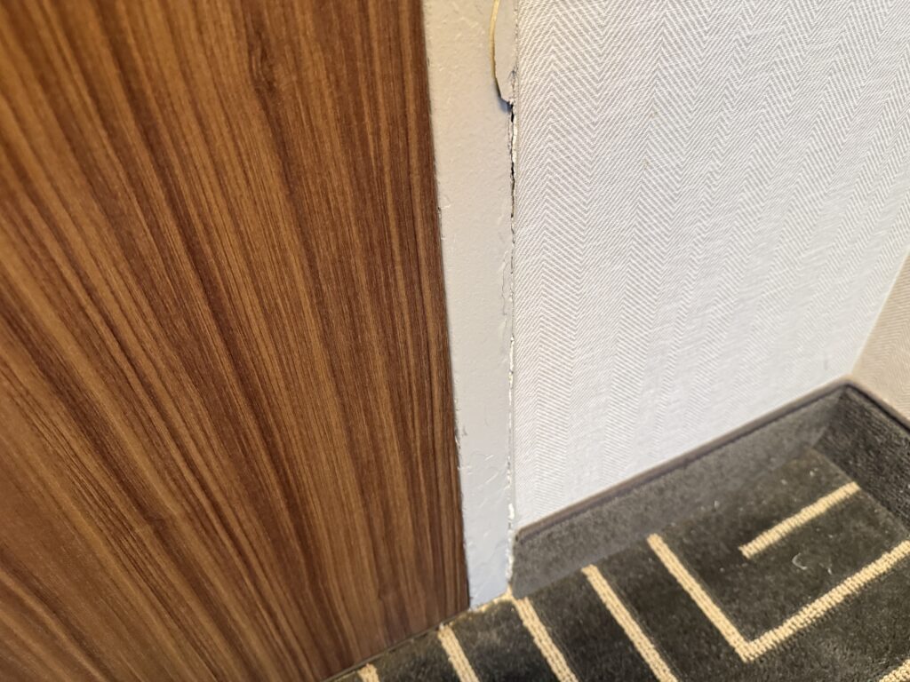 Close-up of a door frame that has a black scuff on it. 
