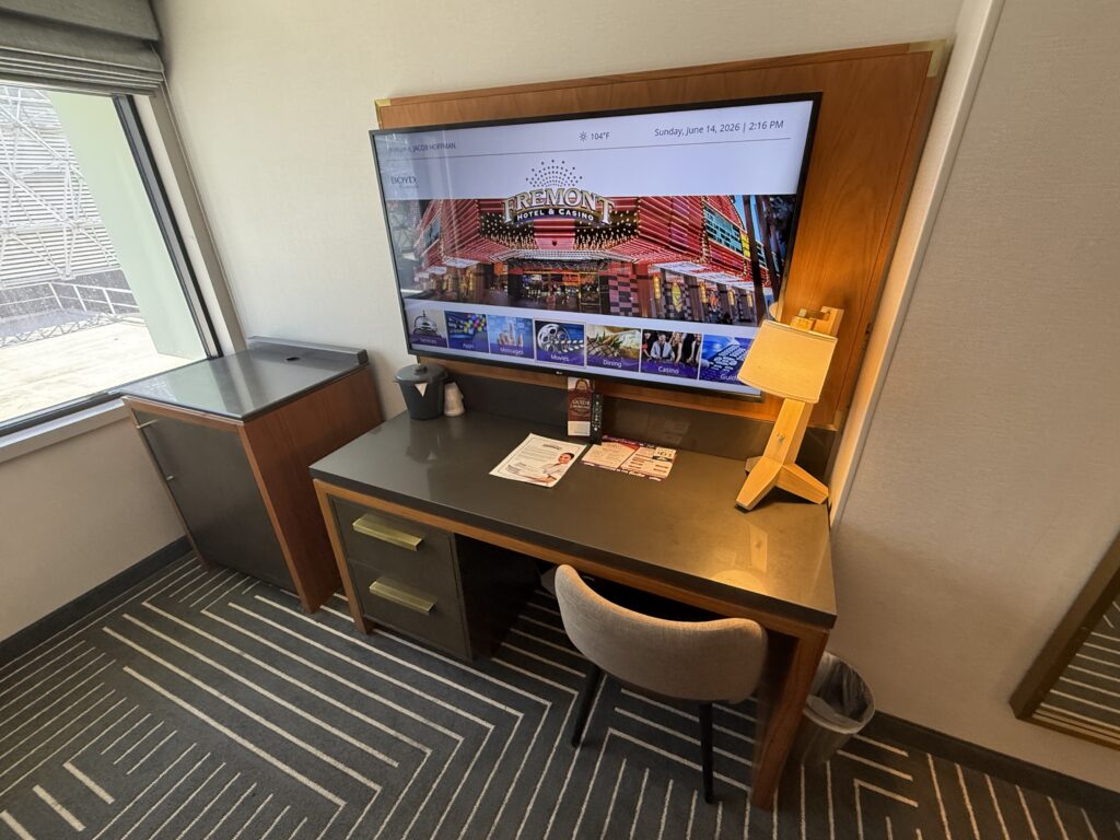 A workdesk with a TV mounted above it. 
