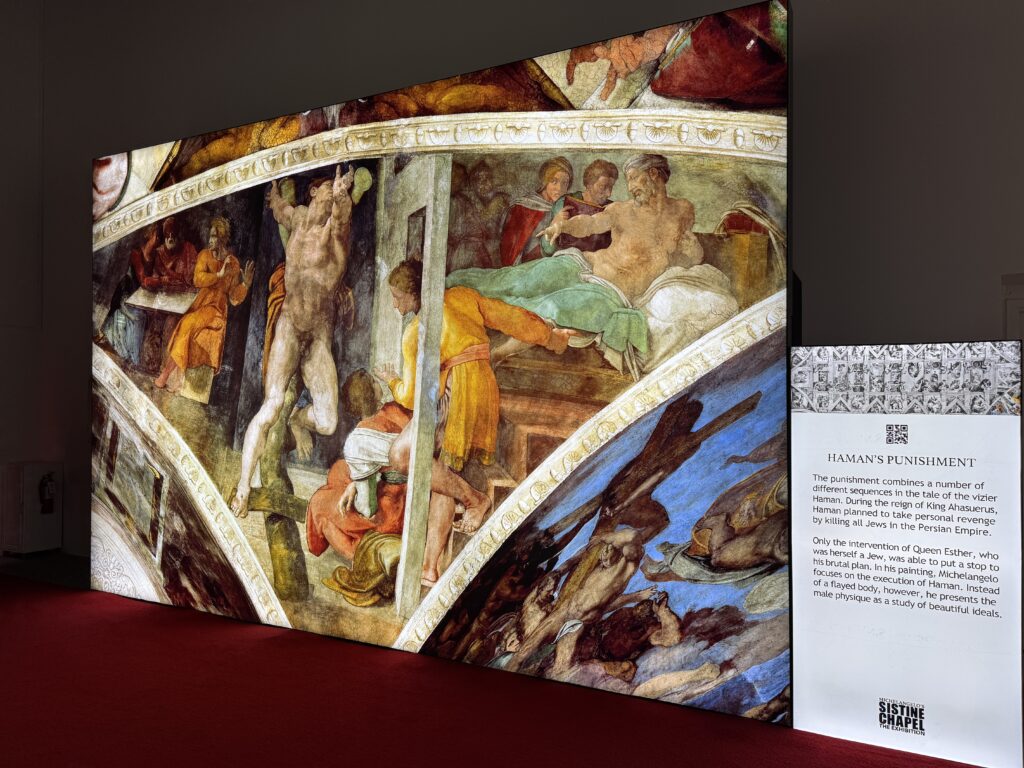 A reproduction of Haman's Punishment next to a written explaination of the painting's meaning. 