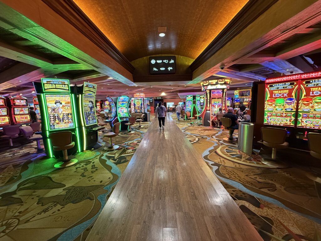 A walkway cutting through rows of slot machines on either sides at TI Las Vegas.