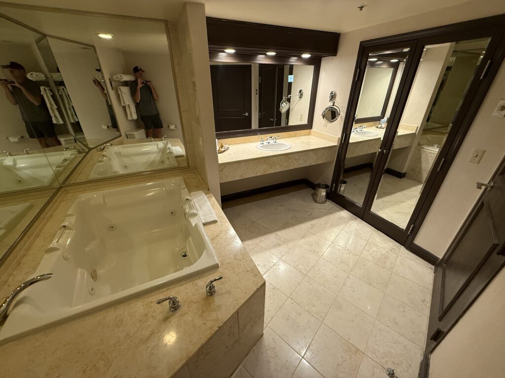 Bathroom with a single sink vanity, and a large jetted tub.