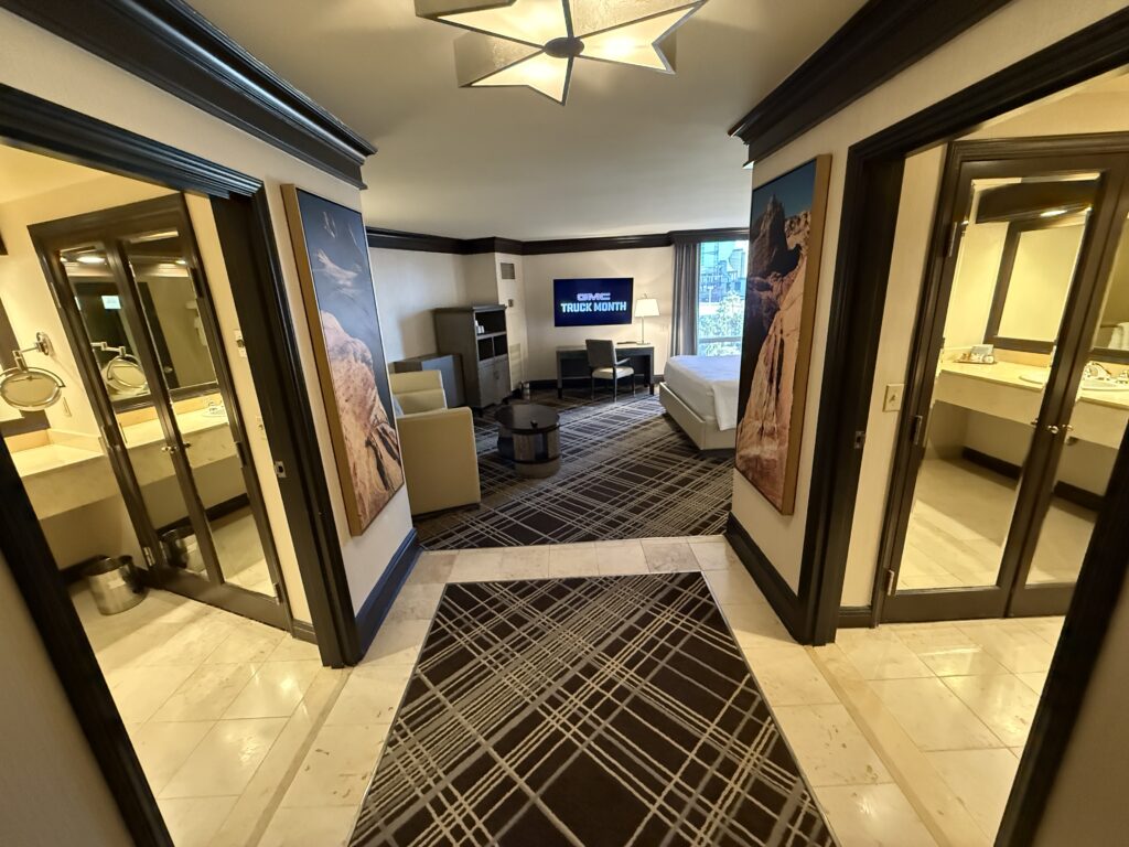 Entryway to the suite, which is wide, bright, and has doors leading into bathrooms on either side.