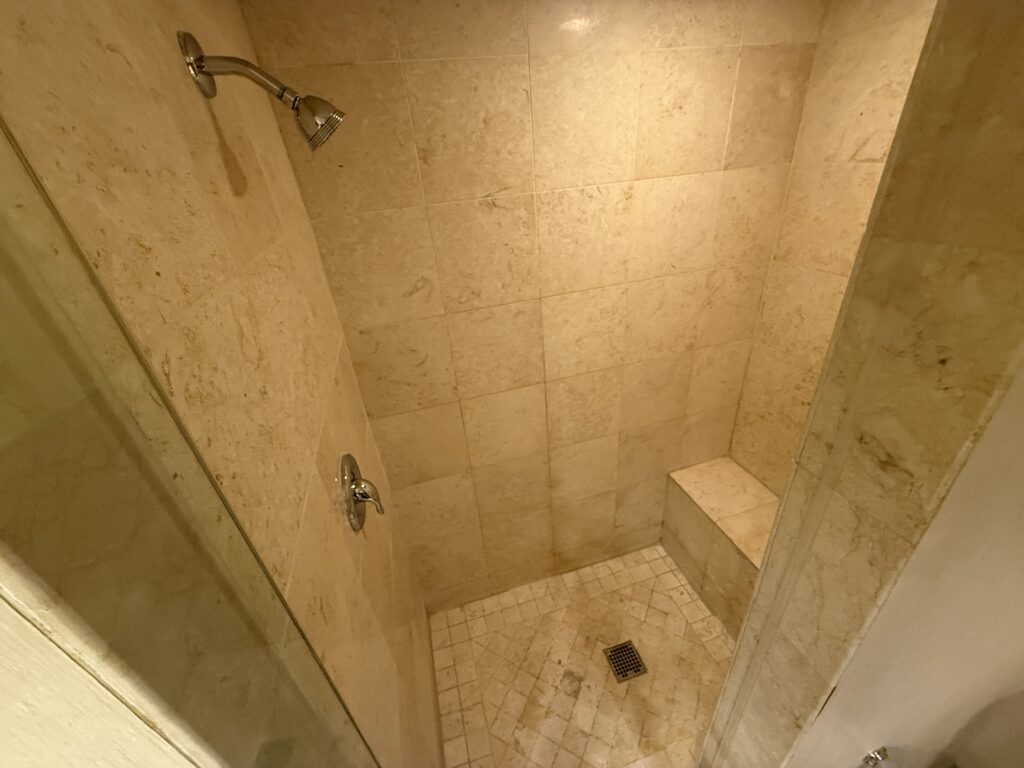 Inside the tile shower, which has a bench.