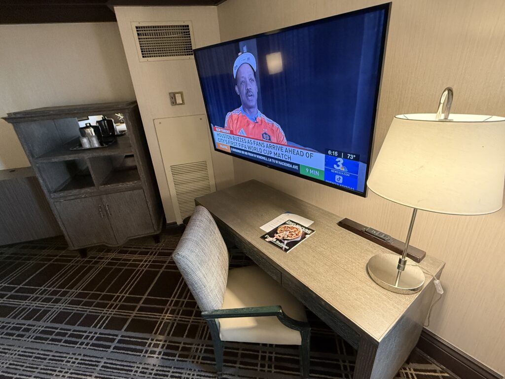 Wall mounted TV above a work desk.